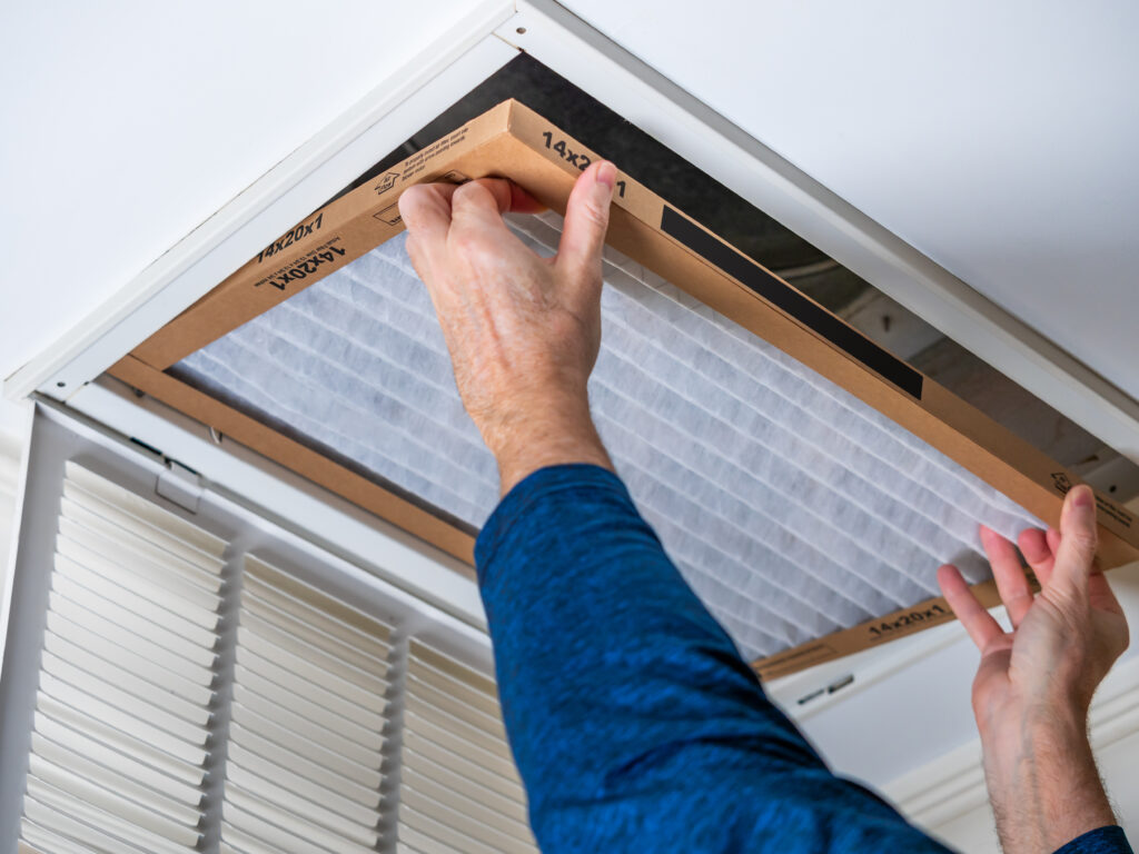 HVAC technician replacing a home air filter in Hawthorne