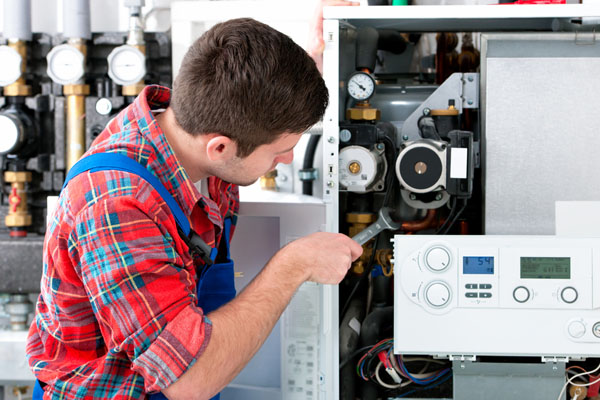 Heating technician repairing boiler controls in Hawthorne