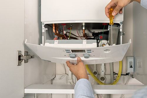 Heating technician repairing a residential boiler in Hawthorne