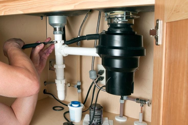 Plumber repairing a garbage disposal in Hawthorne