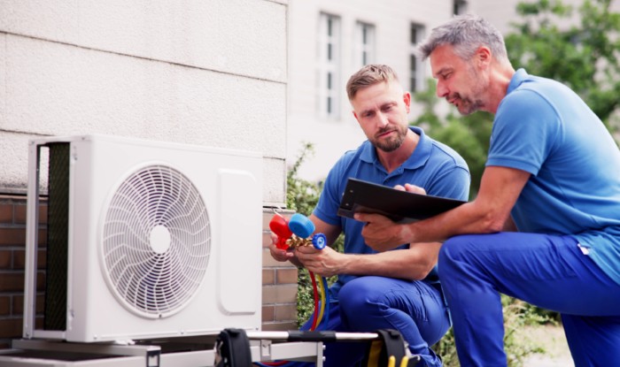 HVAC technicians installing an outdoor air conditioning unit in Hawthorne
