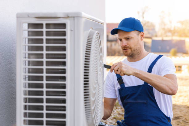 HVAC technician servicing an outdoor air conditioner in Hawthorne