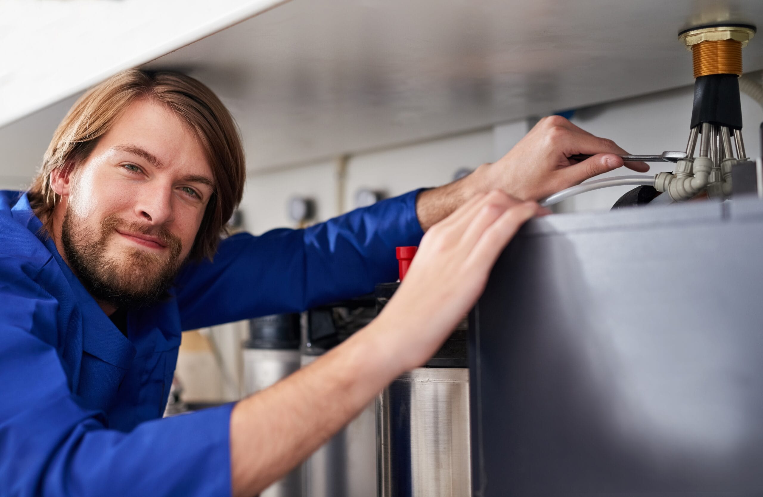 Technician servicing a residential water heater tank in Hawthorne